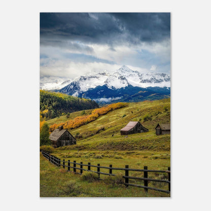 Telluride, Colorado poster featuring rustic barns, rolling meadows, and snow-capped mountains under a dramatic sky.