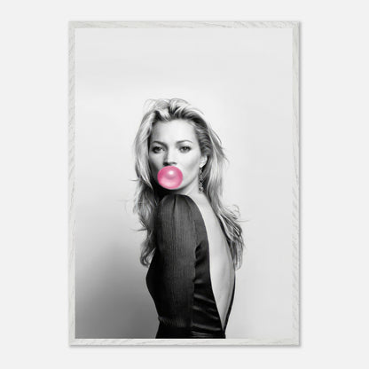 Vintage black-and-white portrait of Kate Moss blowing pink bubble gum in a sleek black dress, framed elegantly.