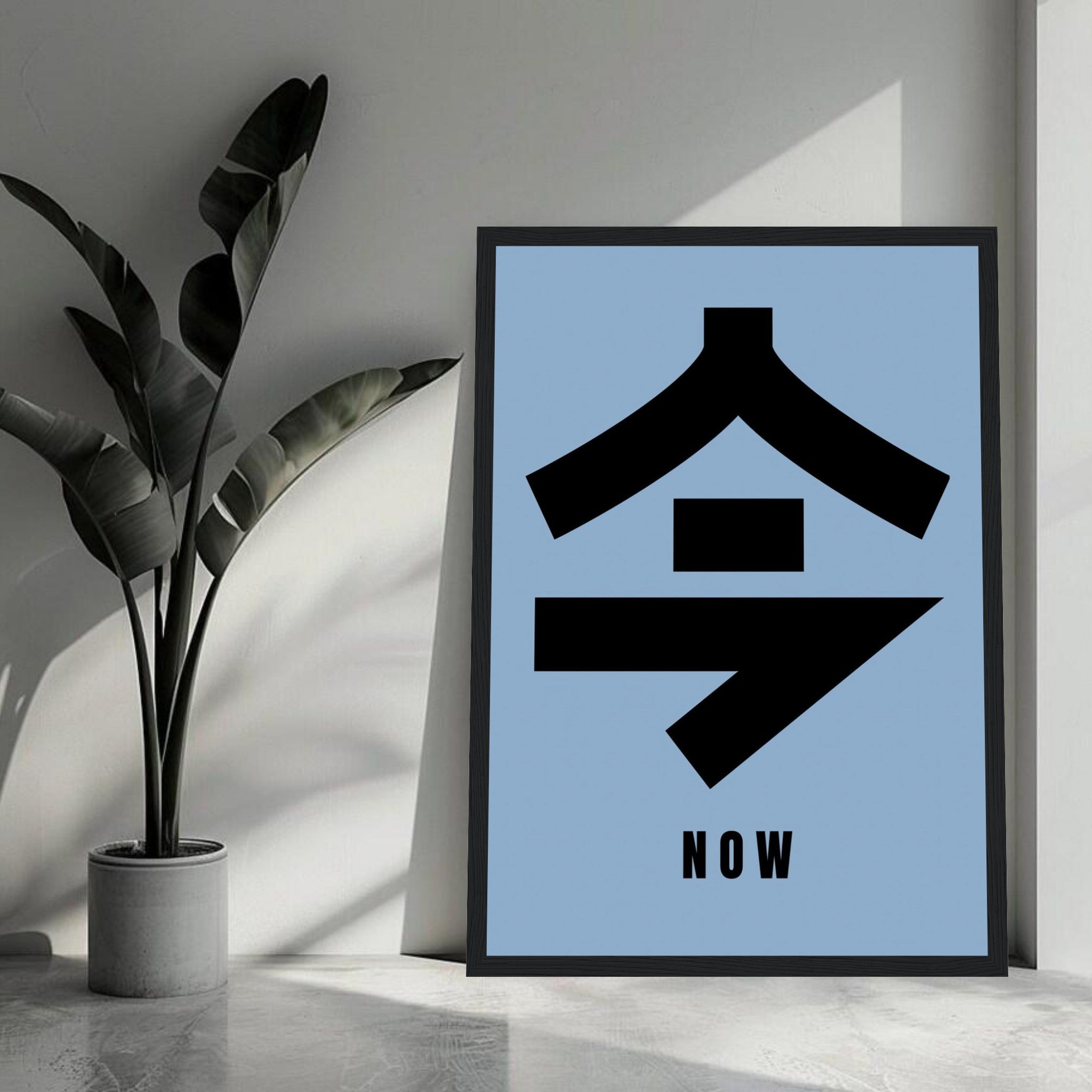 Framed print of Japanese kanji 今 meaning 'now' in black on a blue background, ideal for home decor.