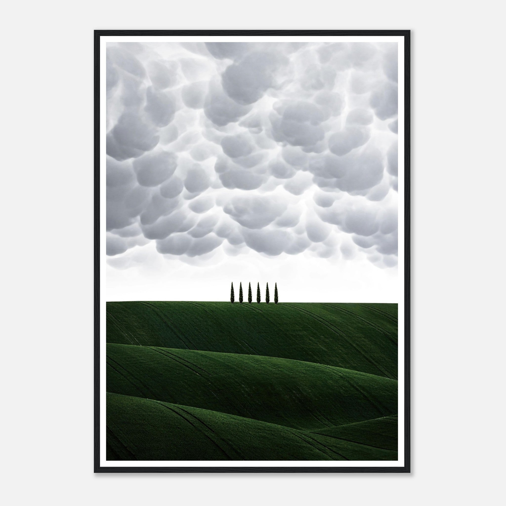 Toscana framed print featuring rolling green hills and cypress trees under dramatic clouds, perfect for elegant decor.