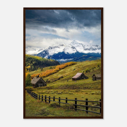 Framed print of Telluride, Colorado featuring rustic barns and snow-capped mountains against a dramatic sky.