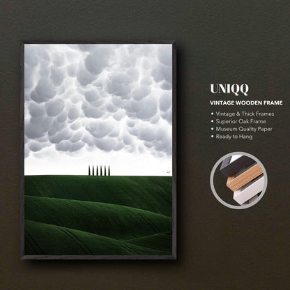 Vintage framed art depicting Tuscany's green hills and cypress trees, showcasing atmospheric clouds above.