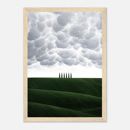 Toscana framed print featuring rolling green hills and cypress trees under dramatic clouds, perfect for elegant decor.