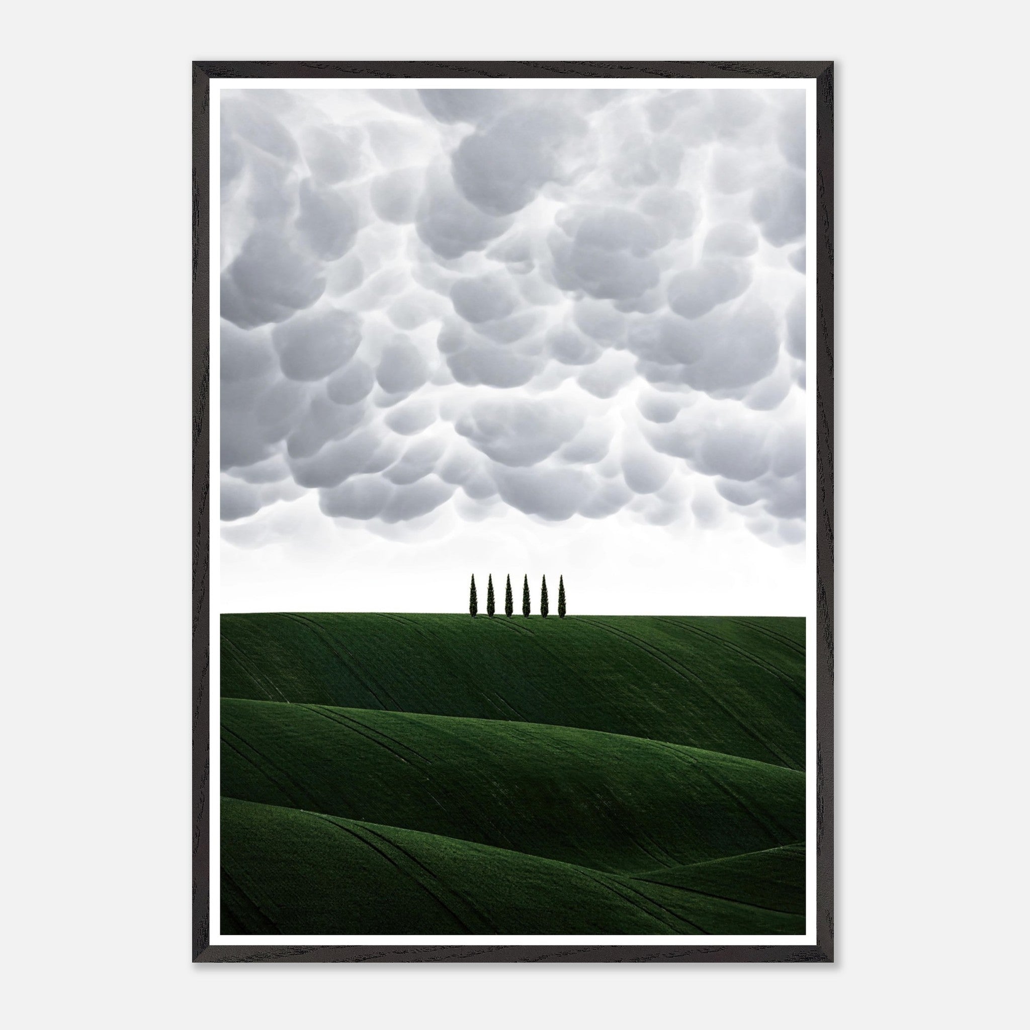 Beautiful framed art depicting Tuscany's rolling green hills and cypress trees under a dramatic sky.