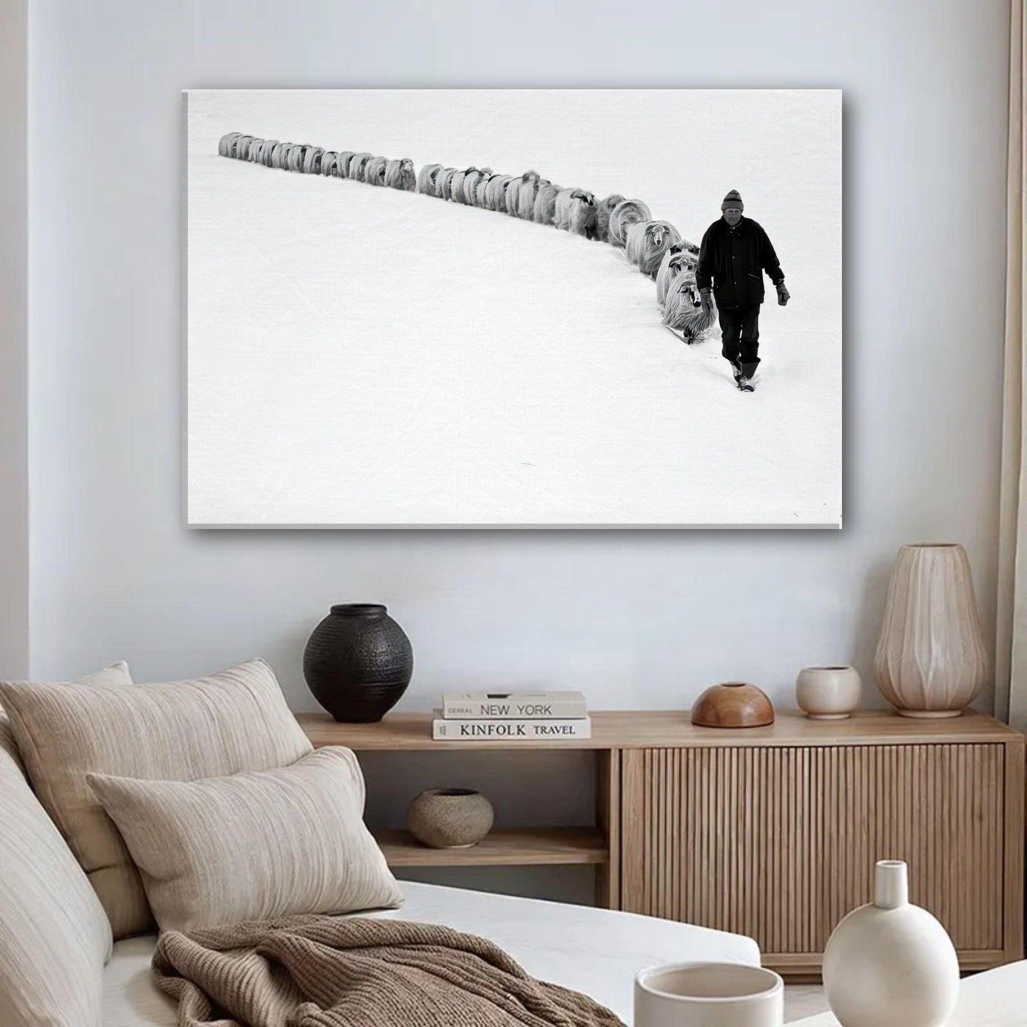 A shepherd guiding a flock through a snowy landscape, captured in black-and-white on a canvas print.