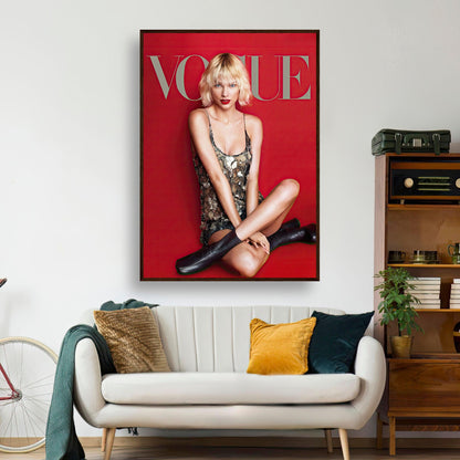 Taylor Swift Vogue Framed Poster featuring a stylish woman in a metallic dress against a red backdrop, showcased in a modern living room.