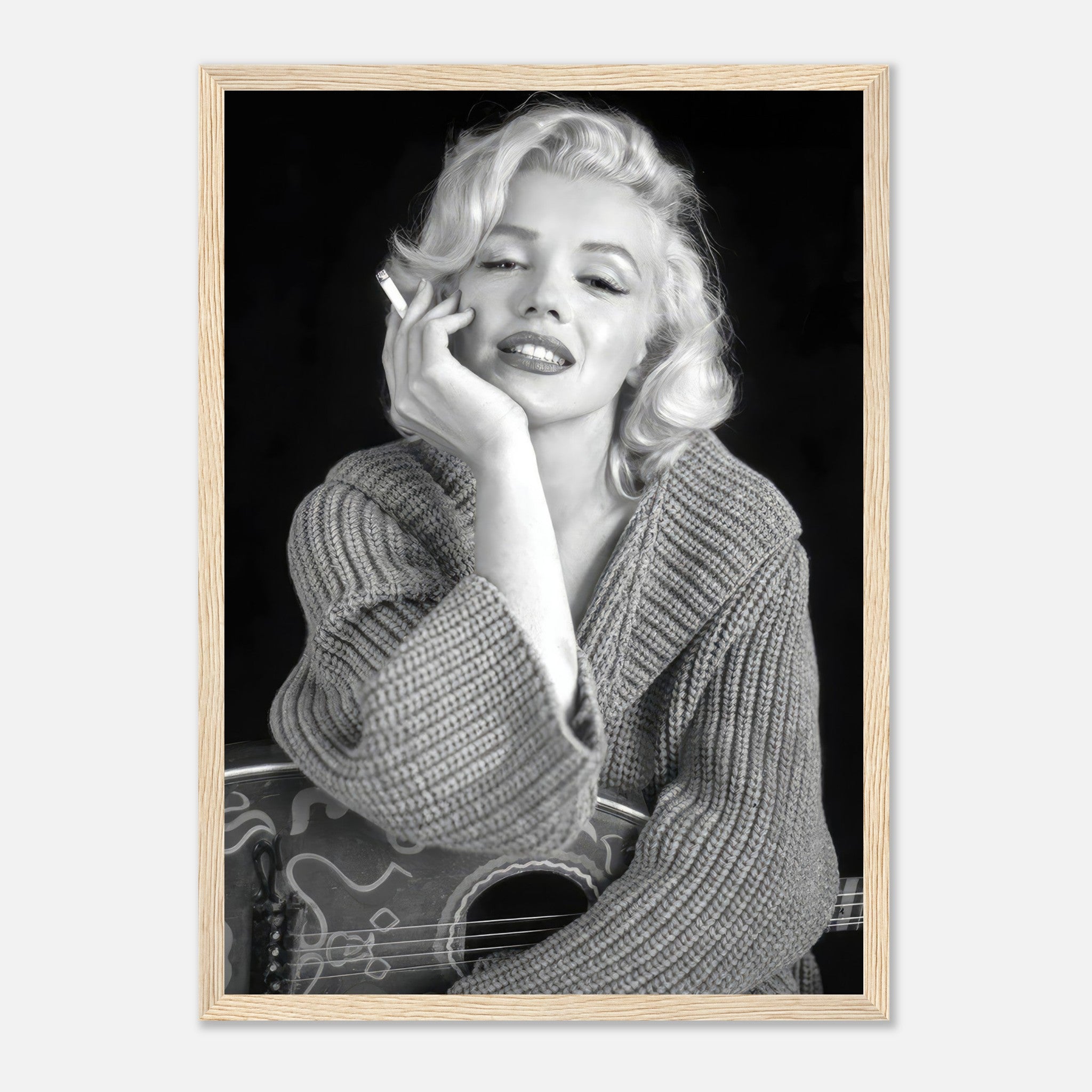 Marilyn Monroe smoking with a guitar in a cozy sweater, framed black-and-white poster exuding timeless elegance.