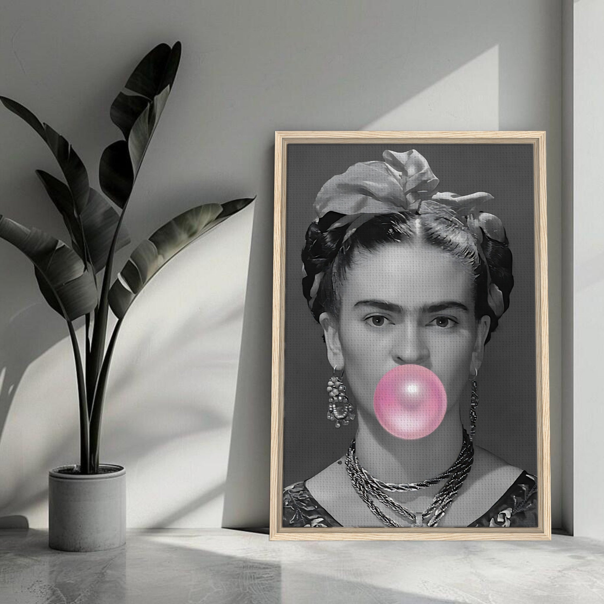 Frida Kahlo Bubble Gum framed canvas print in grayscale, featuring Kahlo blowing a pink bubble gum bubble in a stylish interior setting.