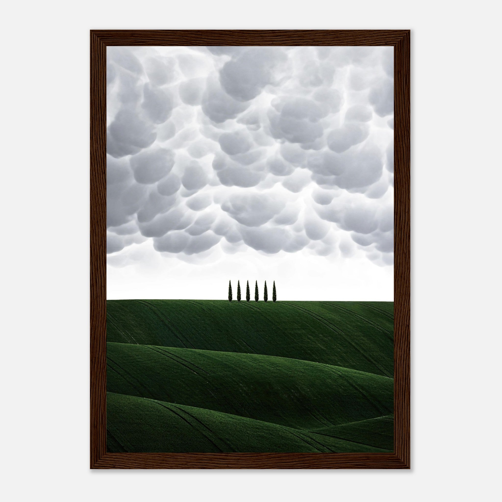 Framed print of Tuscany's rolling green hills and cypress trees under a dramatic sky, enhancing your space with elegance.